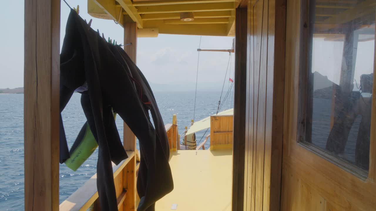 Swimming wetsuits sway on a clothesline in the wind aboard a tourist ship at sea