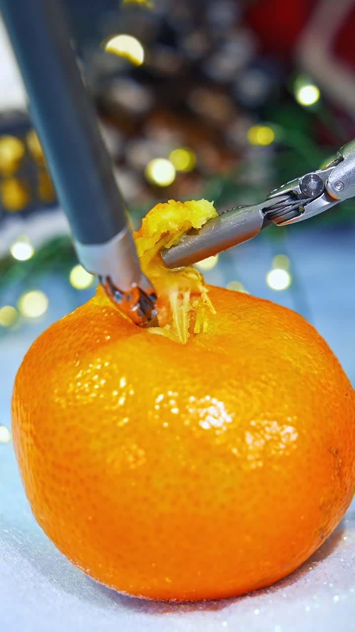 New technology for peeling tangerine at Christmas. New Year preparation with modern high-tech equipment. Close-up. Vertical video