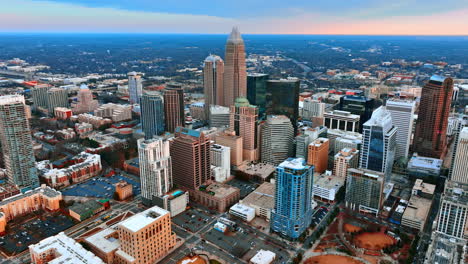 flying closer to the high-rise architecture in the uptown of charlotte, nc, us. vast scenery with lots of greenery at backdrop