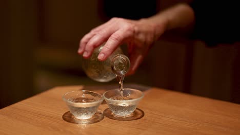 sequence of pouring clear liquid into small cups