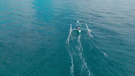 drone following filipino man in boat catching fish with hand lines in the philippines