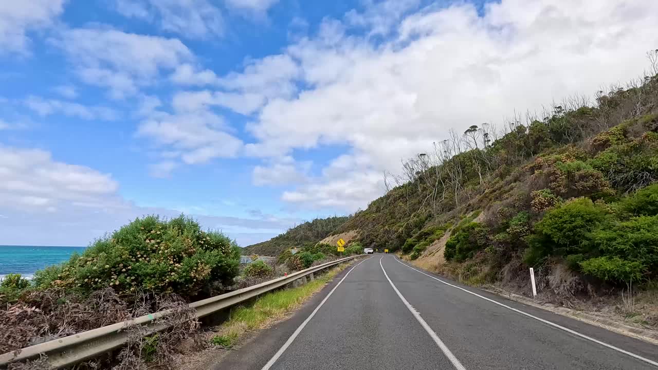 A 14-second video capturing a drive along the picturesque Great Ocean Road, showcasing coastal views and lush greenery under a bright sky