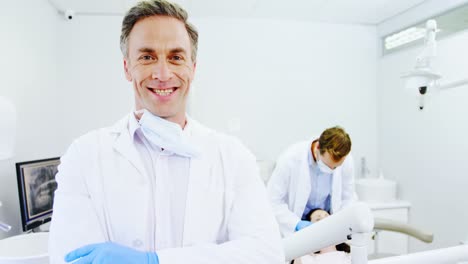 smiling dentist standing with arms crossed
