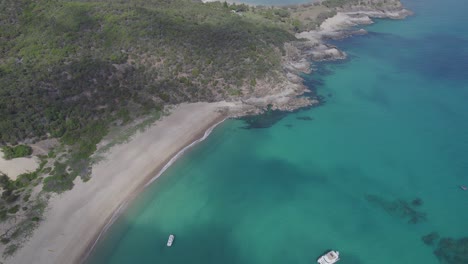 Wrackstrand-Mit-Booten-Auf-Dem-Türkisfarbenen-Ozean-In-Great-Keppel-Island,-Qld,-Australien---Luftdrohnenaufnahme