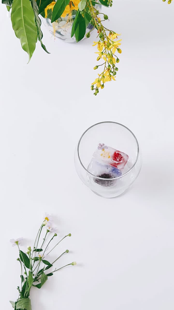 Cubetti di ghiaccio floreali in ciotola di vetro con fiori