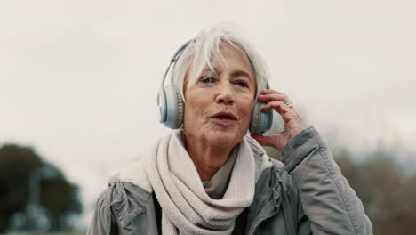 Old-woman,-headphones-and-listening-to-music