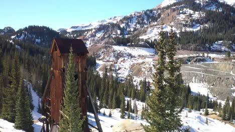 abandoned antique mining building in mountains of colorado with drone moving forward