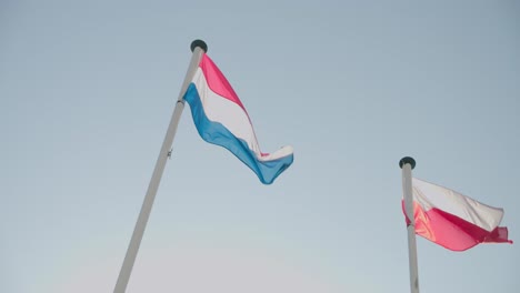 Low-Angle-Shot-Von-Luxemburg-Und-Polen-Fahnenschwingen-Im-Wind