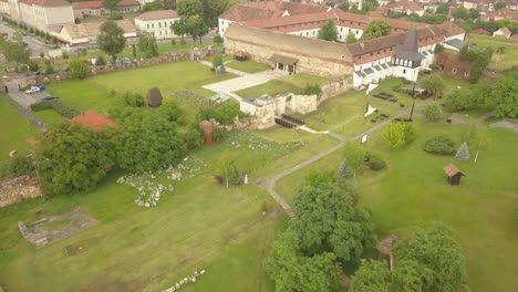 aerial establishing shot of citadel walls-ruins with orthodox roofs and trees visible in alba-carolina , alba-iulia, romania