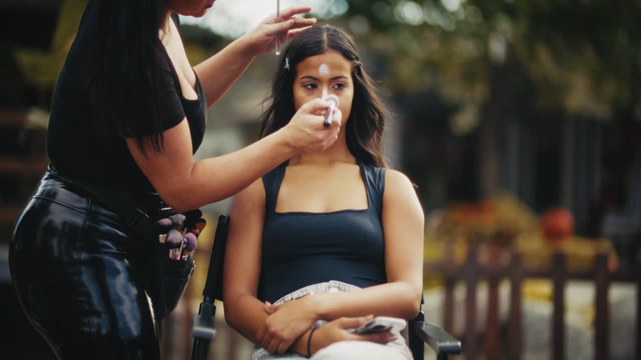 메이크업 아티스트가 모델에게 메이크업을 하고 있습니다.