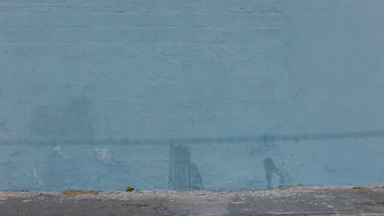 아름다운 예술가 여성이 분홍색 페인트로 벽을 칠하고 도시 거리를  ⁇ 고 자신감 있는 반항적인 여성이 도시 그래피티 예술로 예술적 표현을 즐기고 있습니다.