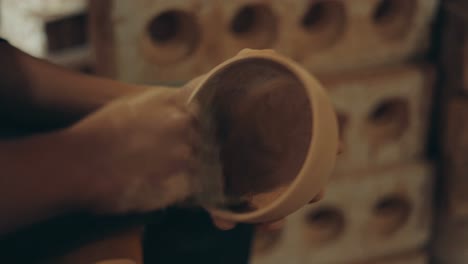 sanding a handmade clay bowl - process of clay bowl making - close up