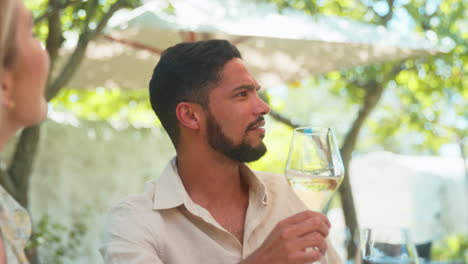 grupo de amigos disfrutando de la degustación de vino al aire libre en una visita al viñedo