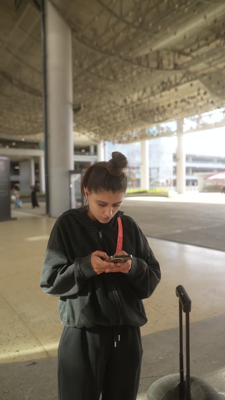 mujer usando teléfono móvil en el aeropuerto