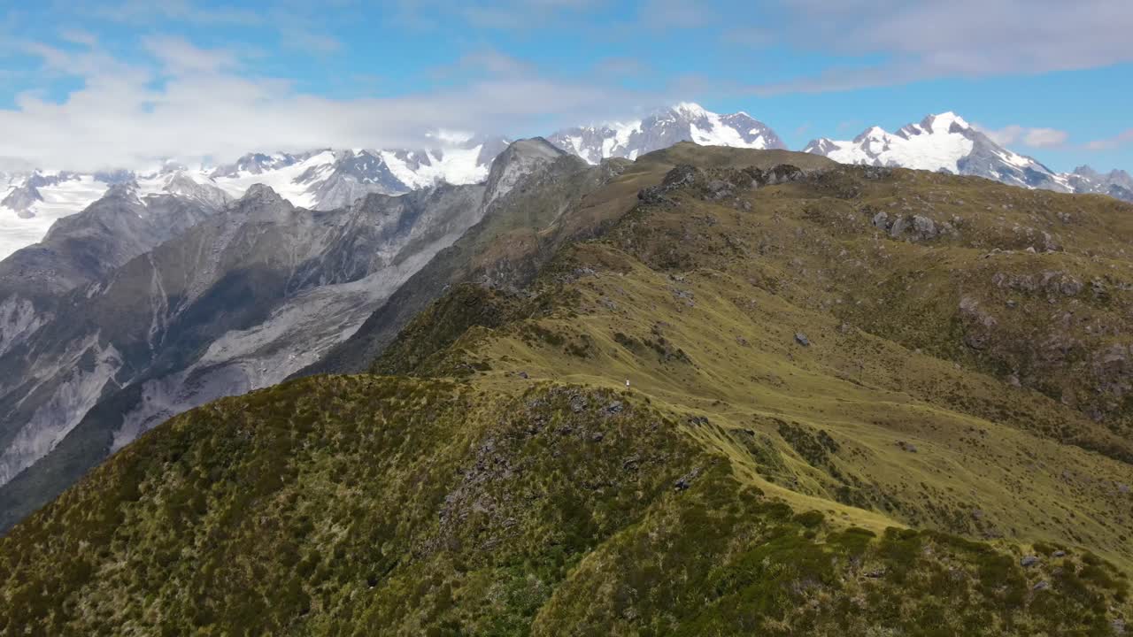 mujer joven en la cresta de la montaña revelación aérea de impresionantes paisajes alpinos de altas montañas en nueva zelanda