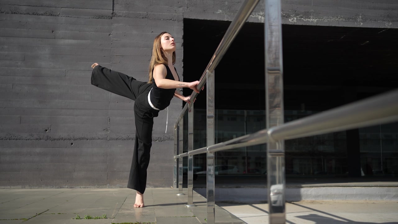 Servizio fotografico di moda elegante con modella in abito nero sullo sfondo di architettura moderna.