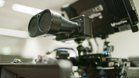 Camera-tilts-from-a-lens-mounted-on-a-professional-high-end-cinema-camera-to-a-focus-assist-tool,-an-ultrasonic-distance-measeure-mounted-on-top-of-the-camera