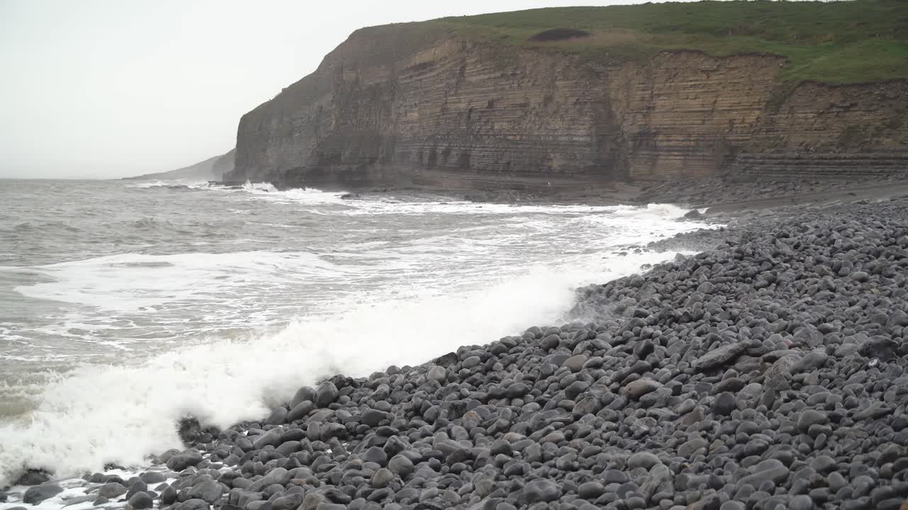 plano general de la marea de invierno salpicando sobre la playa rocosa en la bahía de dunraven, gales del sur