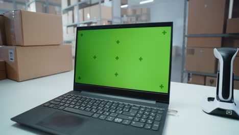 laptop with green screen in warehouse