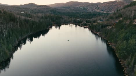 pine trees around serene lake at dusk in saint-come, quebec, canada