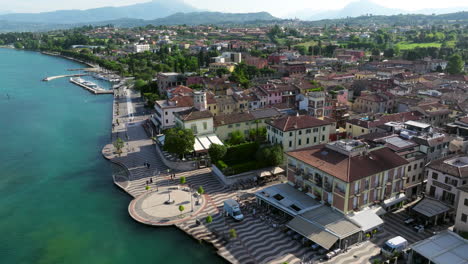aerial view of lakeside town of lazise on shore of lake garda in province of verona, italy. orbiting shot
