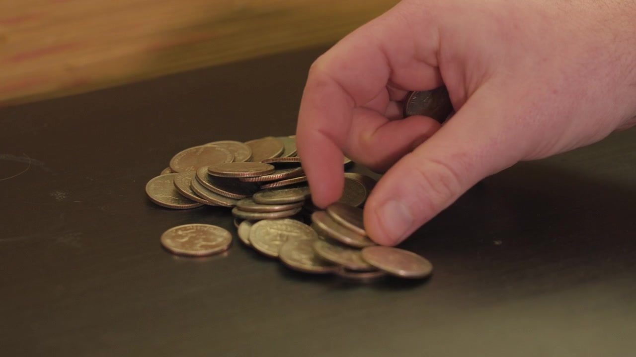 Contando uma pilha de moedas de 25 centavos em close-up.