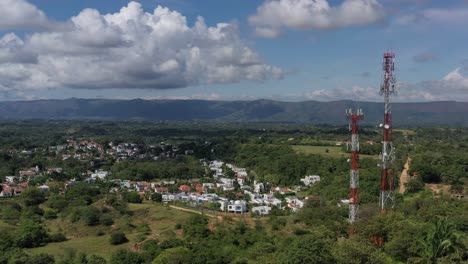 toma aérea de drones de antenas de tecnología móvil con un pueblo detrás de las antenas