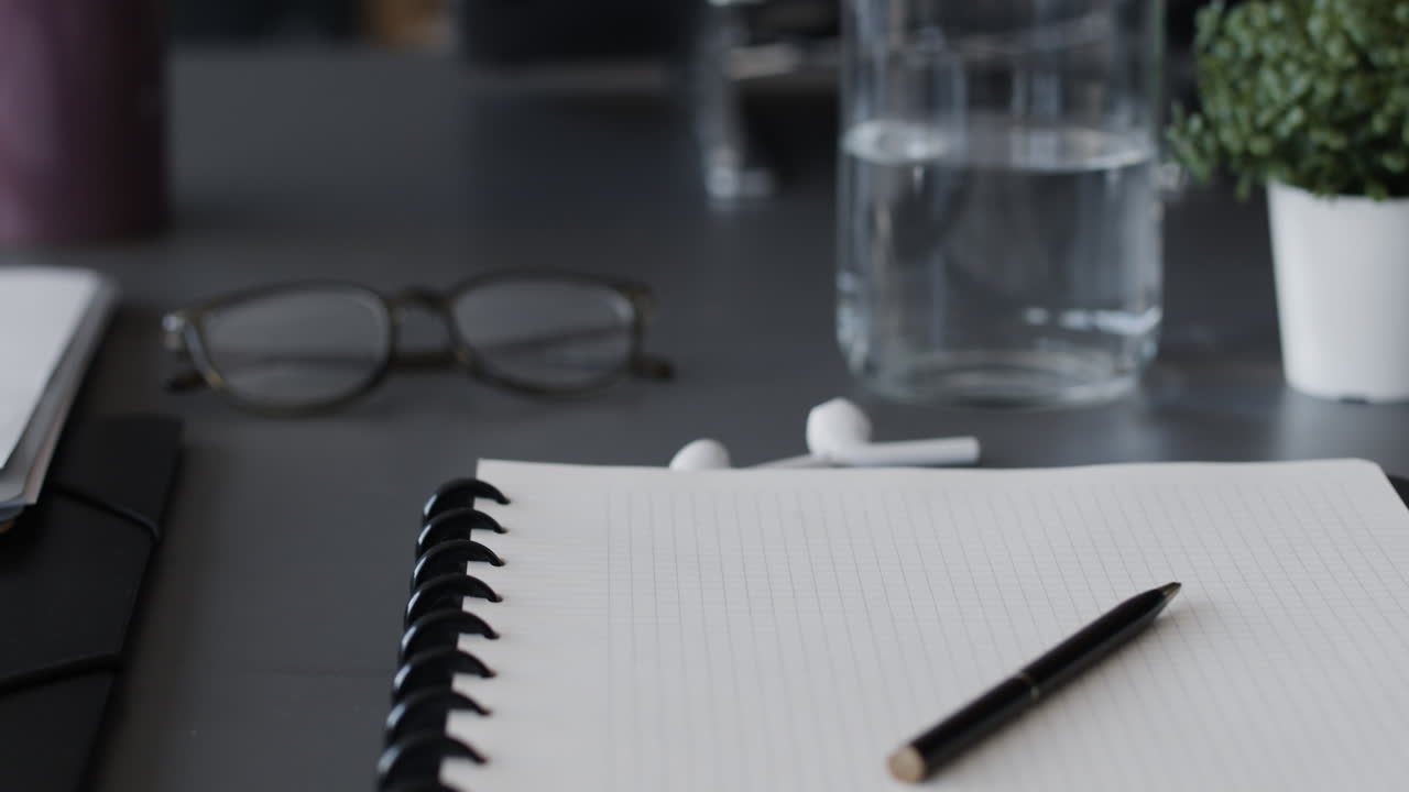 Modern Office Workspace with Notebook, Glasses, and Water Bottle