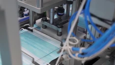 taller de fabricación para la producción de ropa, el proceso de línea de fabricación que produce máscaras faciales médicas con maquinaria automática en una fábrica industrial