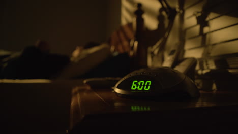 tired woman turns off alarm clock at 6 am and rolls out of bed, static