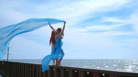 kissing couple on sea pier. pregnant couple kissing on sky background