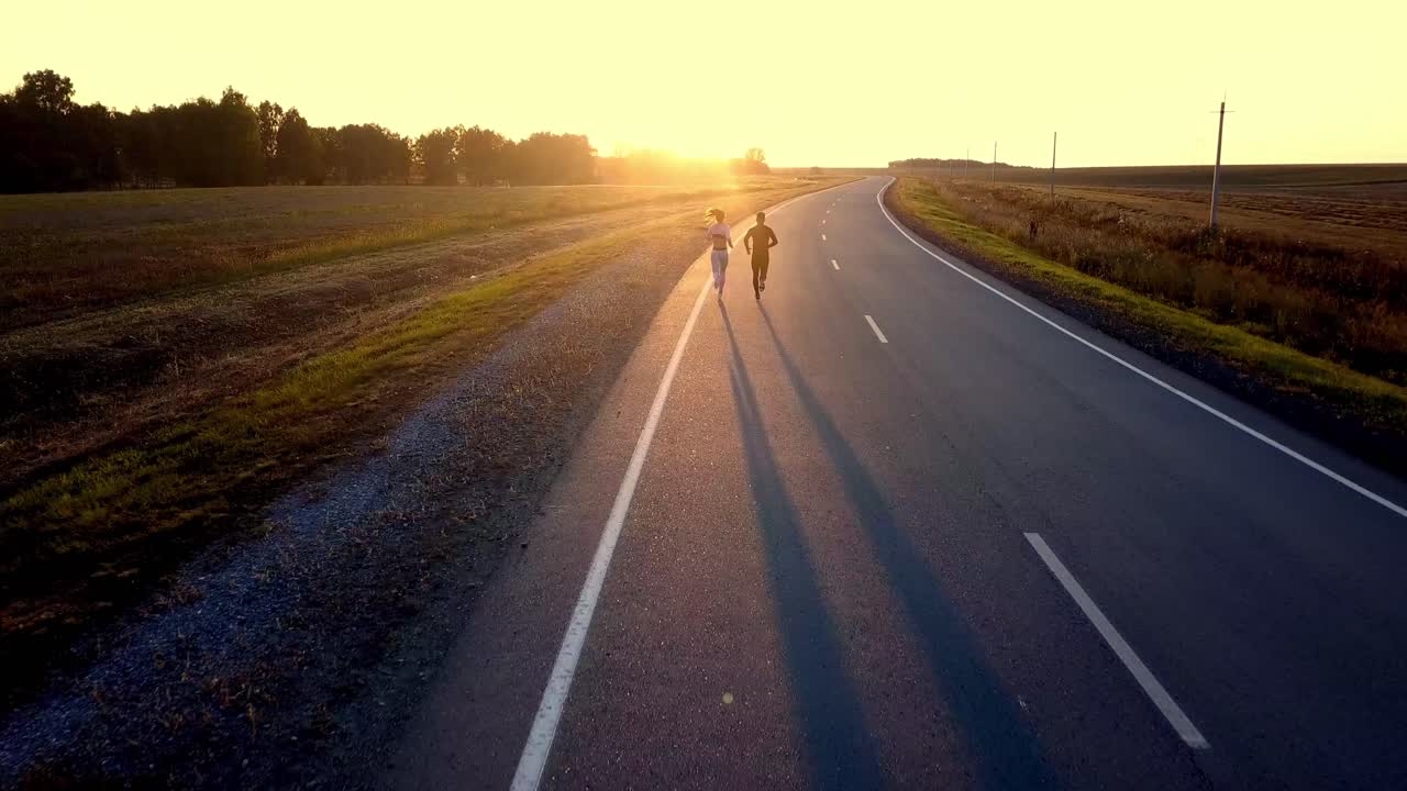 Couple Running on a Road at Sunset