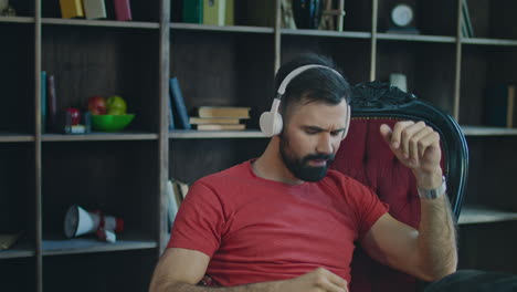 business man dancing in chair. young man listening to music in headphones