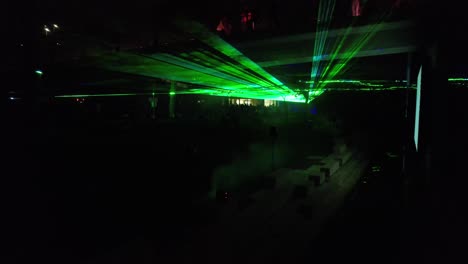 Aerial-view-of-Multi-colored-laser-beams-turning-into-shapes,-projection-on-smoke