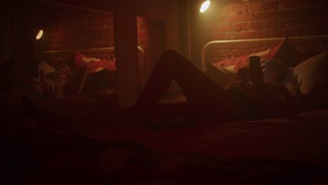 mujer usando el teléfono en un dormitorio por la noche