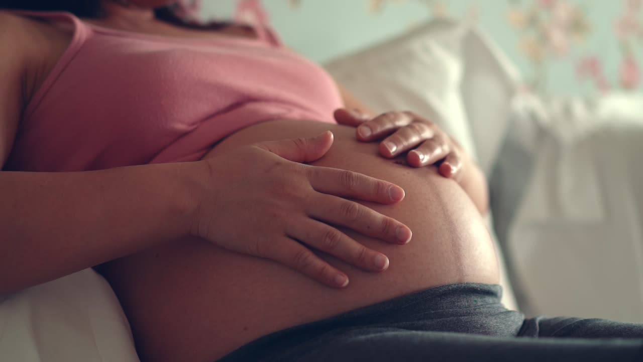 Mujer embarazada feliz y esperando un bebé en casa