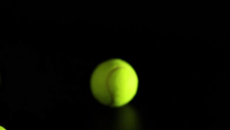 bright tennis balls captured mid-bounce against a dark backdrop, showcasing dynamic motion and energy.