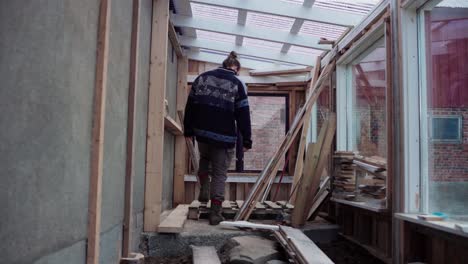 man building a greenhouse in his cabin