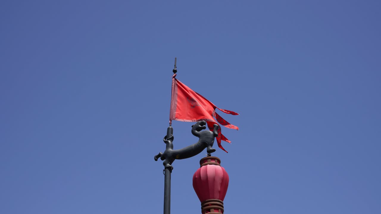 Bandiera rossa cinese che sventola al vento sopra una lanterna rossa a Xian.