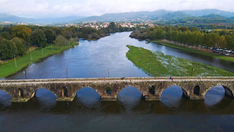 Atemberaubende-4K-Drohnenaufnahmen-Aus-Der-Luft-Eines-Dorfes-–-Ponte-De-Lima-In-Portugal-Und-Seines-Wahrzeichens-–-Einer-Steinernen-Römischen-Brücke-über-Den-Fluss-Lima