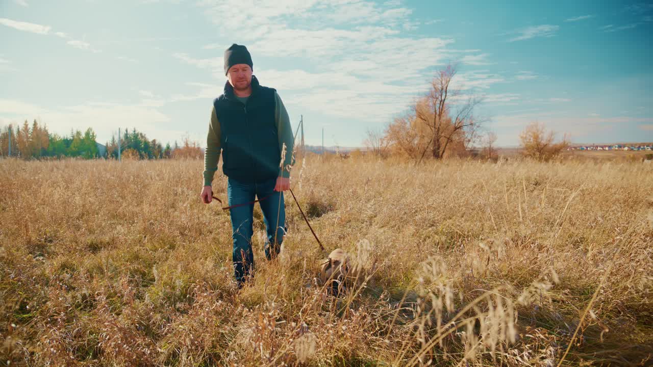 A Man Enjoys a Serene Walk with His Dog Through a Lush Green Field on a Clear Day, Surrounded by Nature's Beauty and the Warmth of the Sun Under a Bright Blue Sky