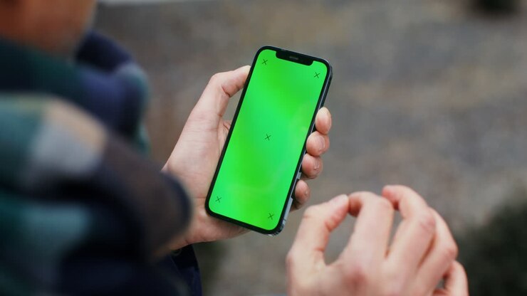 Persona che tiene uno smartphone con schermo verde