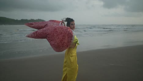 la mujer india disfruta de su día en la playa y juega con la brisa