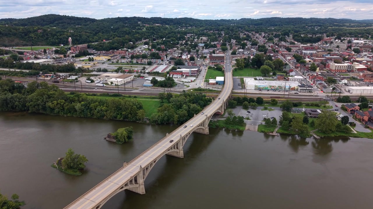 Una vista aerea con drone che mostra il lungo e storico ponte ad arco in cemento Veterans Memorial Bridge che attraversa l'ampio fiume Susquehanna verso Columbia, Pennsylvania