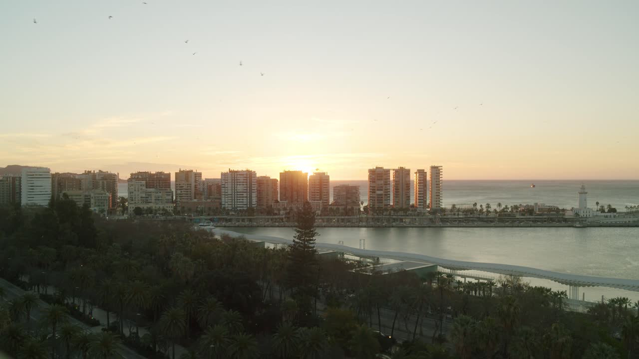 Nascer do sol épico atrás dos arranha-céus no porto de Málaga, logo pela manhã.