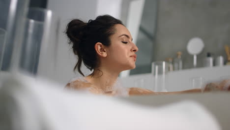 mujer caucásica lavando la piel en el baño