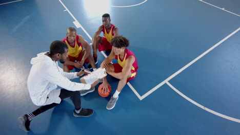 hombres afroamericanos y biraciales hacen estrategia en la cancha de baloncesto