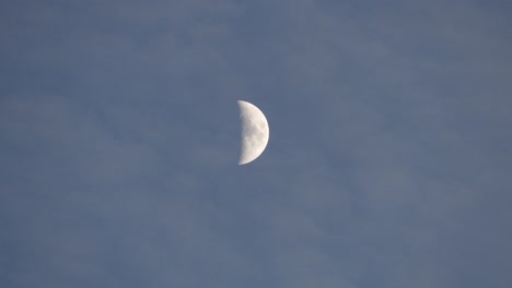 light blue sky, the crescent moon and moving clouds,