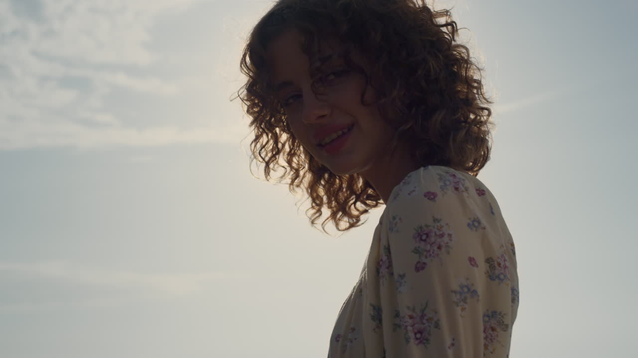 chica hermosa mirando a la cámara frente a la luz del sol brillante. modelo posando en la naturaleza.