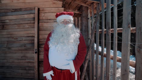 Der-Weihnachtsmann-Spricht-Im-Winter-Vor-Einem-Kleinen-Holzhaus